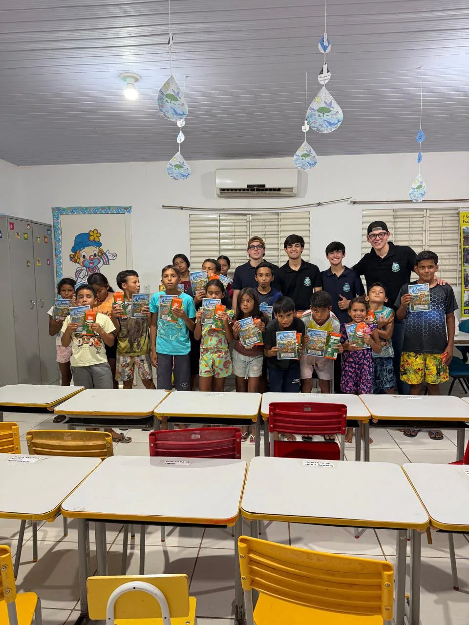 Crianças e equipe do Águas Pantaneiras Educa com os livros na escola de Cuiabá Mirim
